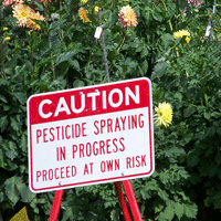 CAUTION - pesticide spraying in progress - proceed at own risk