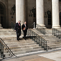 men in suits on steps of a government building